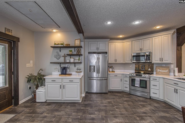 kitchen with stainless steel appliances, white cabinetry, sink, and a textured ceiling