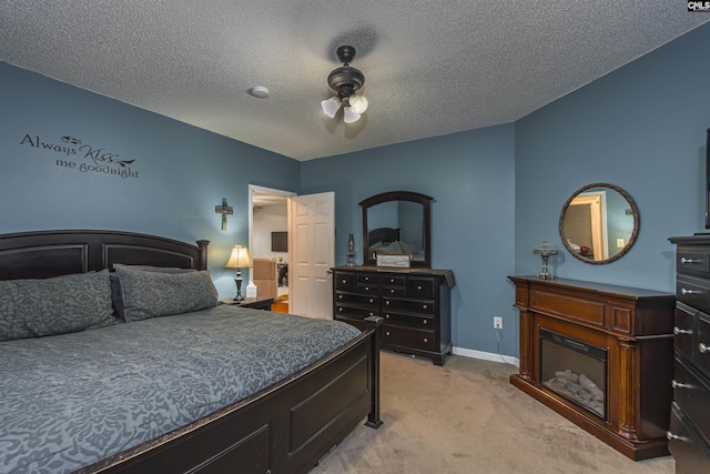 carpeted bedroom with ceiling fan and a textured ceiling