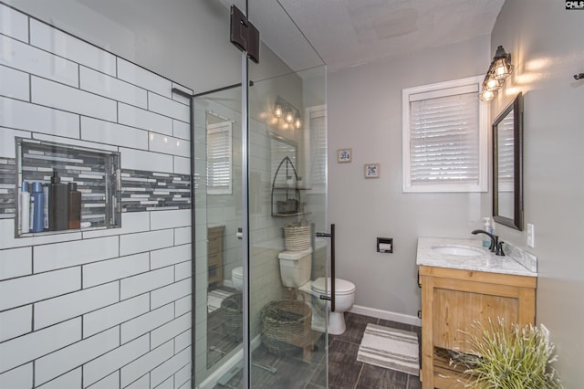 bathroom with walk in shower, vanity, and toilet