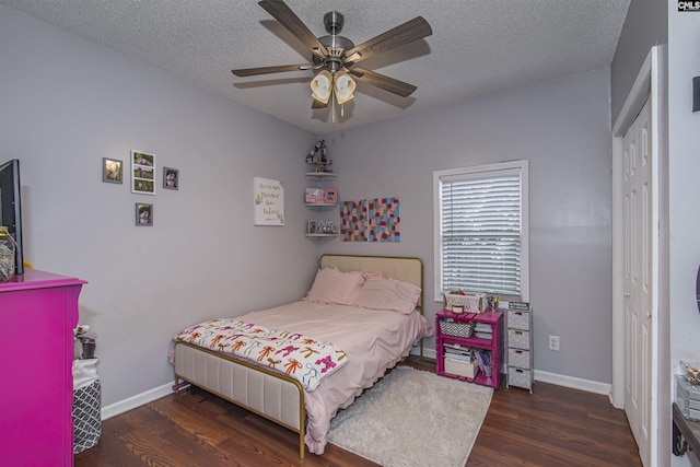 bedroom with ceiling fan, dark hardwood / wood-style floors, and a textured ceiling