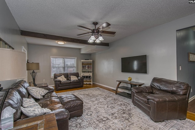 living room with hardwood / wood-style floors, a textured ceiling, and ceiling fan