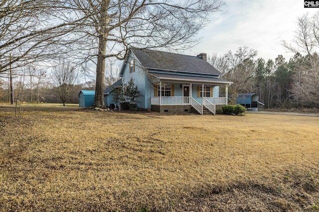 view of front of home with a storage shed, a front lawn, and a porch