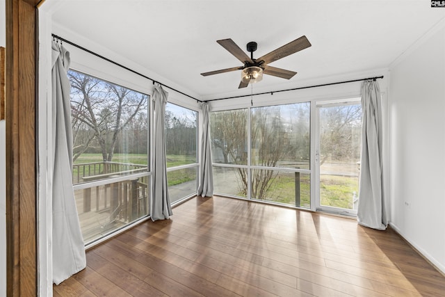 unfurnished sunroom with ceiling fan