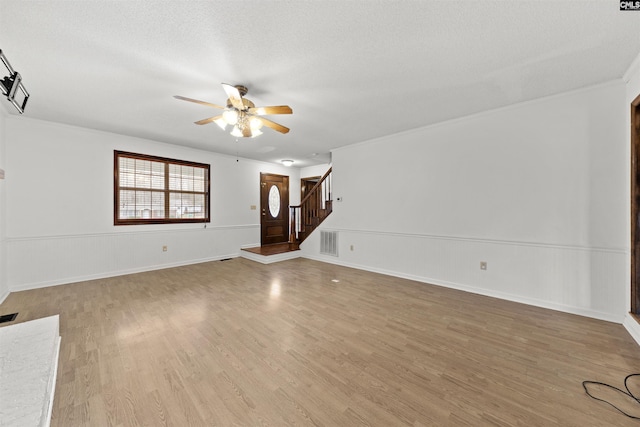 unfurnished living room featuring ceiling fan, hardwood / wood-style floors, and a textured ceiling