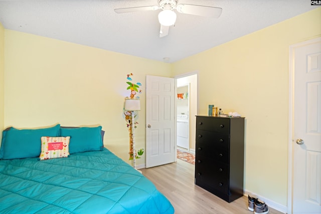 bedroom featuring ceiling fan, washer / clothes dryer, a textured ceiling, and light wood-type flooring