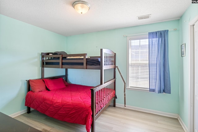 bedroom with hardwood / wood-style floors and a textured ceiling