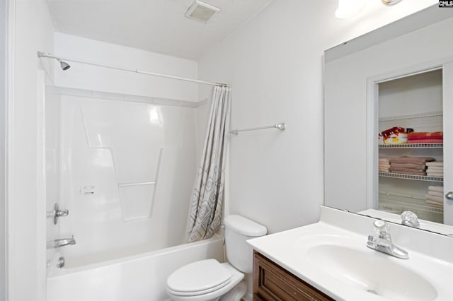 full bathroom with vanity, shower / tub combo, a textured ceiling, and toilet