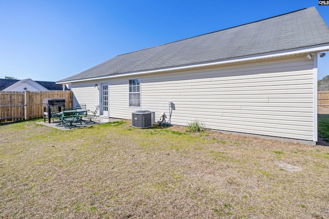 rear view of house featuring a yard, a patio, and central air condition unit