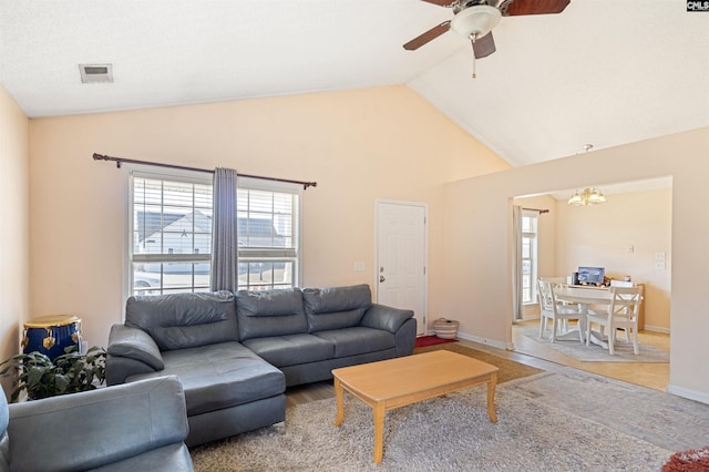 living room featuring ceiling fan with notable chandelier, vaulted ceiling, and hardwood / wood-style floors