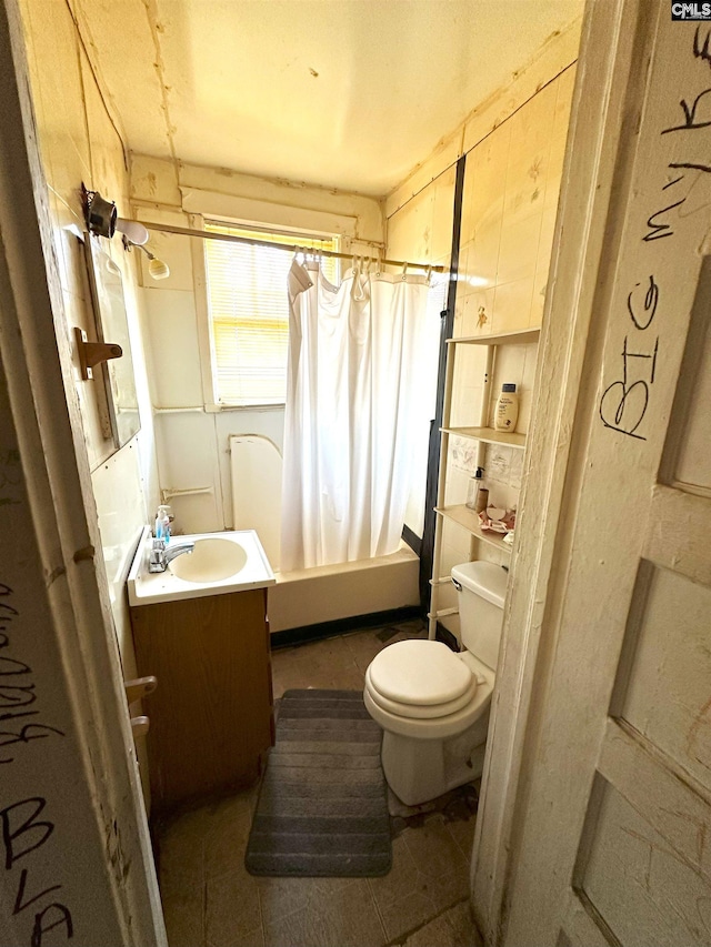 full bathroom featuring tile patterned floors, toilet, shower / bath combo with shower curtain, and vanity