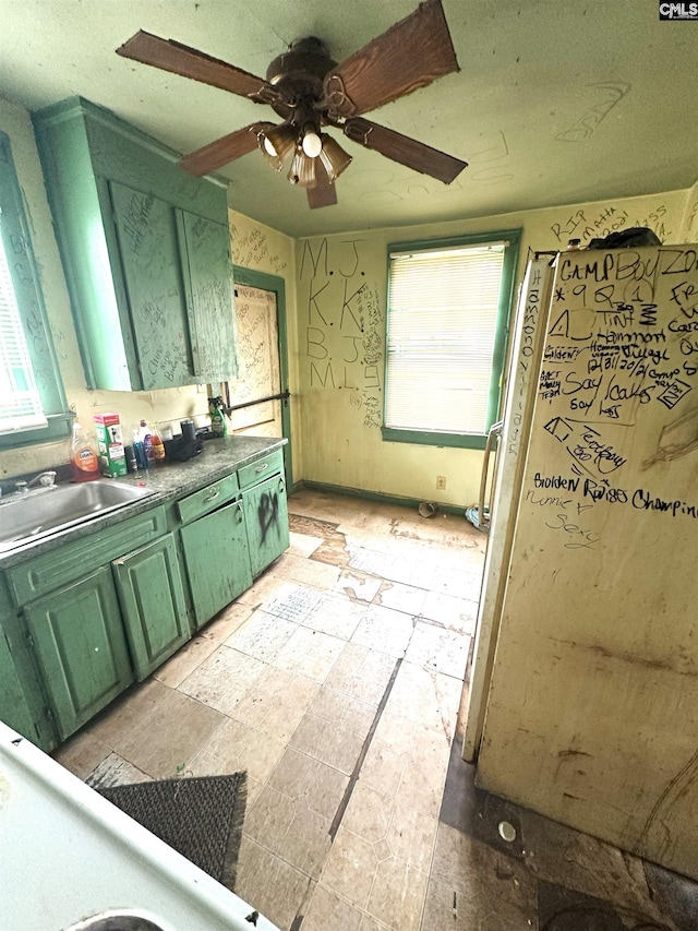 kitchen featuring ceiling fan, sink, and green cabinets