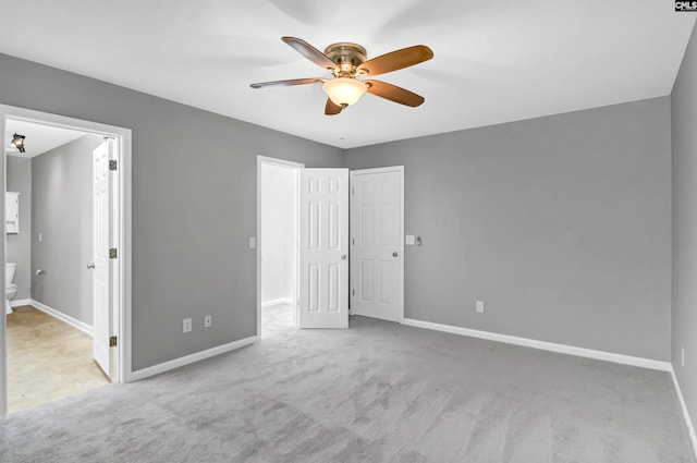 unfurnished bedroom with ceiling fan, light colored carpet, and ensuite bathroom