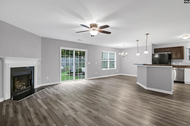 unfurnished living room featuring dark hardwood / wood-style floors and ceiling fan with notable chandelier