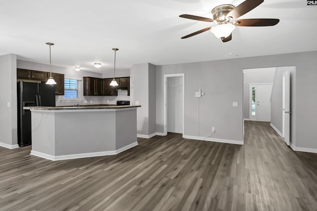 kitchen featuring ceiling fan, black fridge, dark wood-type flooring, and dark brown cabinetry