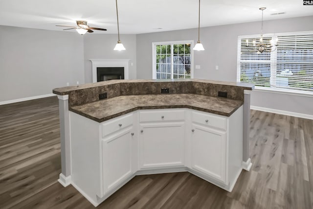 kitchen with white cabinetry, a center island, dark hardwood / wood-style flooring, pendant lighting, and ceiling fan