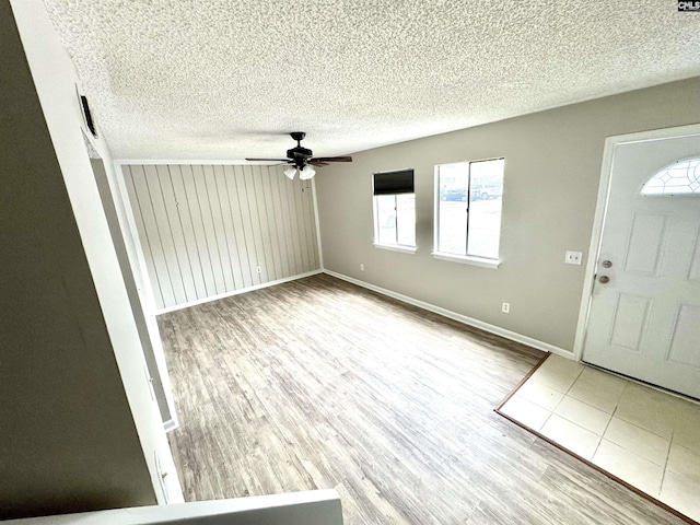 foyer with a wealth of natural light, a textured ceiling, and light wood-type flooring