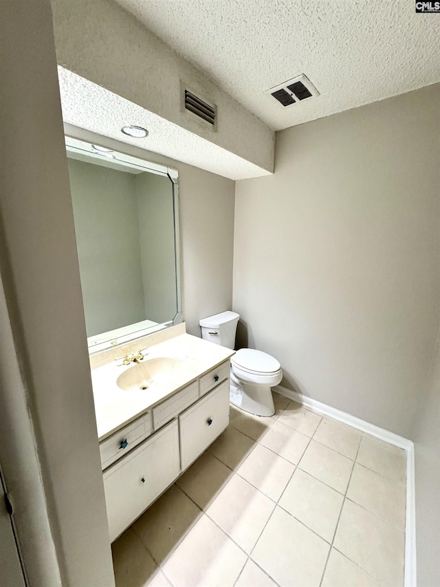 bathroom featuring vanity, tile patterned floors, a textured ceiling, and toilet