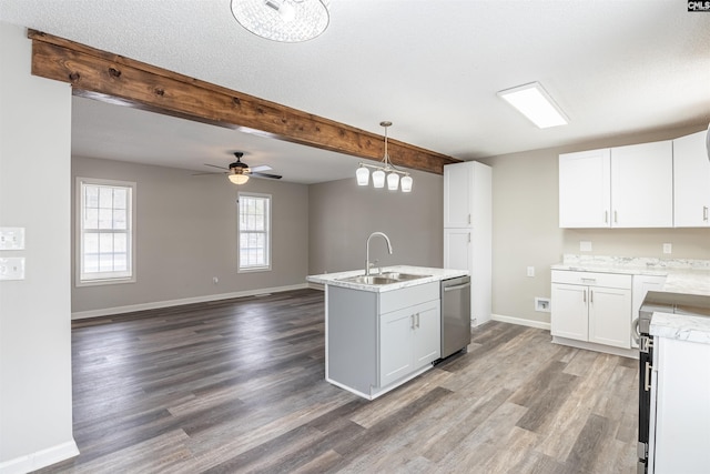 kitchen with appliances with stainless steel finishes, white cabinetry, sink, hanging light fixtures, and a center island with sink