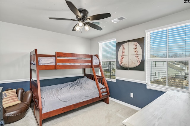 carpeted bedroom with ceiling fan and multiple windows