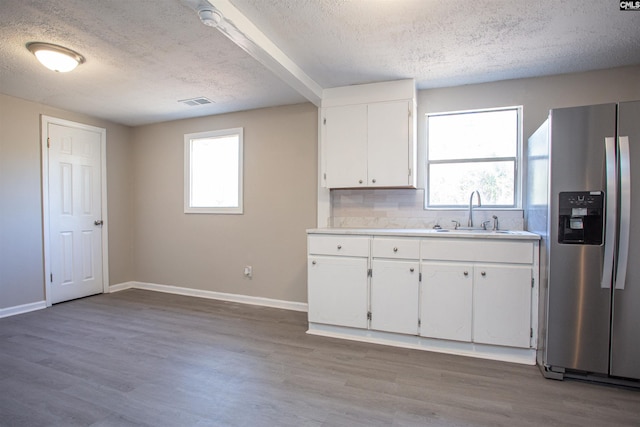 kitchen with white cabinetry, stainless steel fridge with ice dispenser, sink, and light wood-type flooring