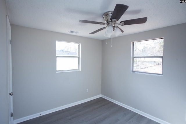 spare room featuring dark wood-type flooring and a textured ceiling