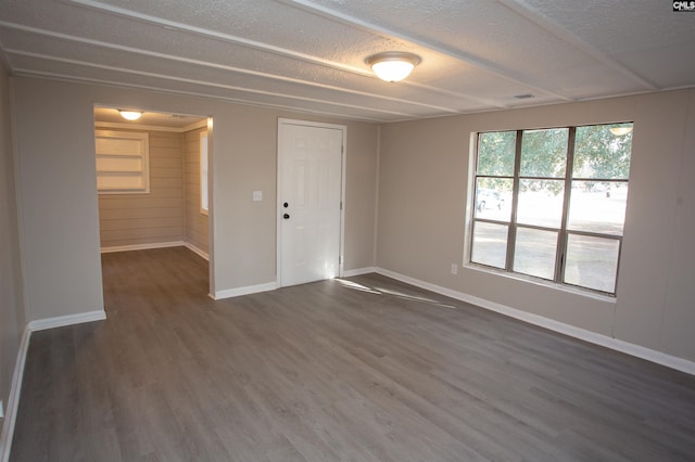 spare room featuring dark hardwood / wood-style floors and a textured ceiling