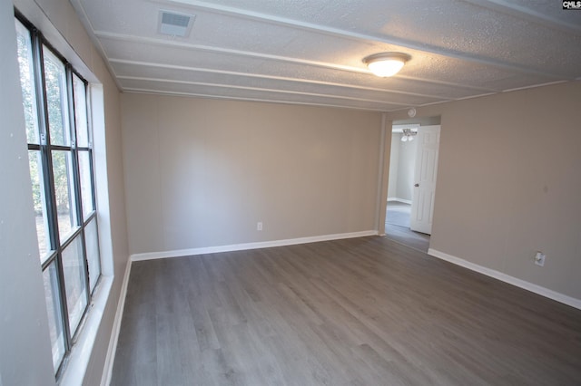 empty room featuring hardwood / wood-style flooring and a textured ceiling