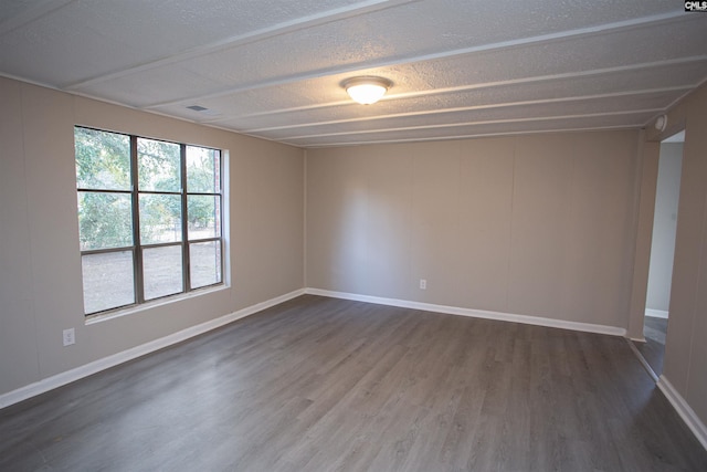 spare room with dark hardwood / wood-style floors and a textured ceiling