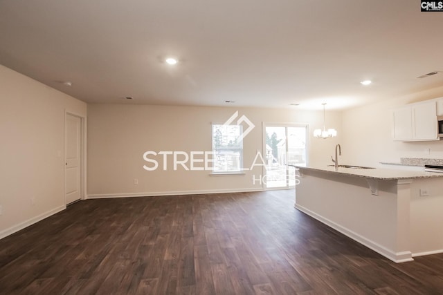 kitchen with visible vents, dark wood-type flooring, white cabinets, light stone countertops, and baseboards