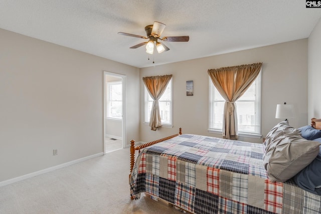 carpeted bedroom with multiple windows, ceiling fan, and a textured ceiling