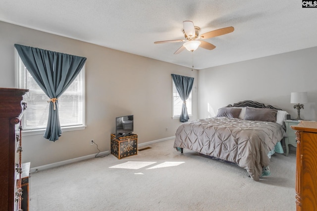 carpeted bedroom with a textured ceiling and ceiling fan