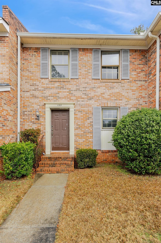 entrance to property with a lawn