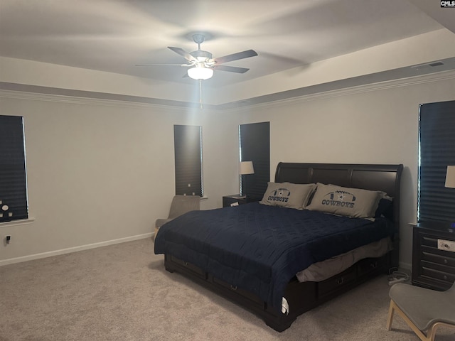 bedroom featuring ceiling fan, light colored carpet, ornamental molding, and a raised ceiling