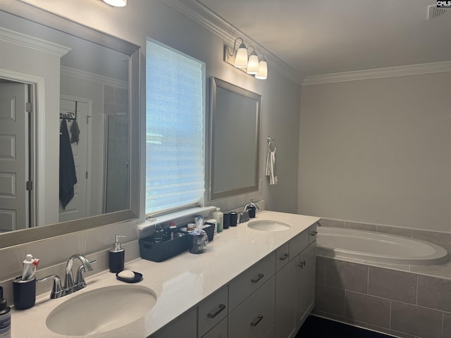 bathroom with vanity, crown molding, and tiled bath