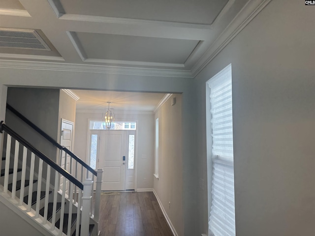 foyer entrance featuring coffered ceiling, a notable chandelier, crown molding, and dark wood-type flooring