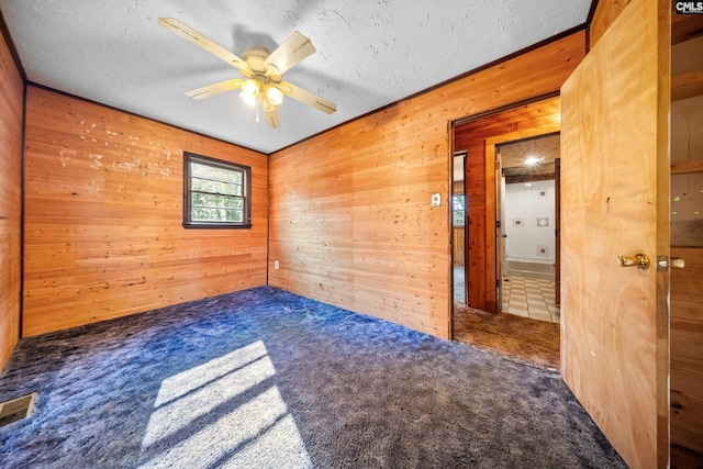104 Brandon Rd, Clinton, SC 29325 - carpeted empty room featuring ceiling fan, a textured ceiling, and wood walls