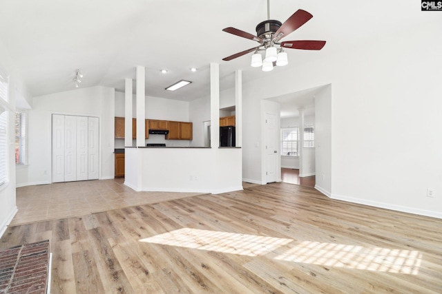 unfurnished living room with vaulted ceiling, ceiling fan, and light wood-type flooring