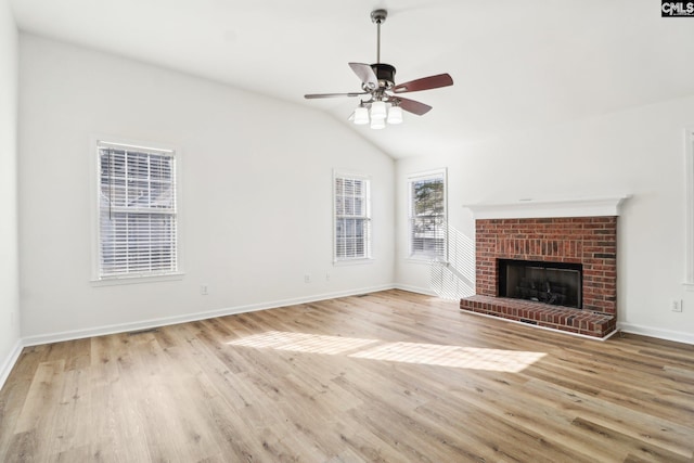 unfurnished living room featuring ceiling fan, lofted ceiling, a fireplace, and light hardwood / wood-style floors