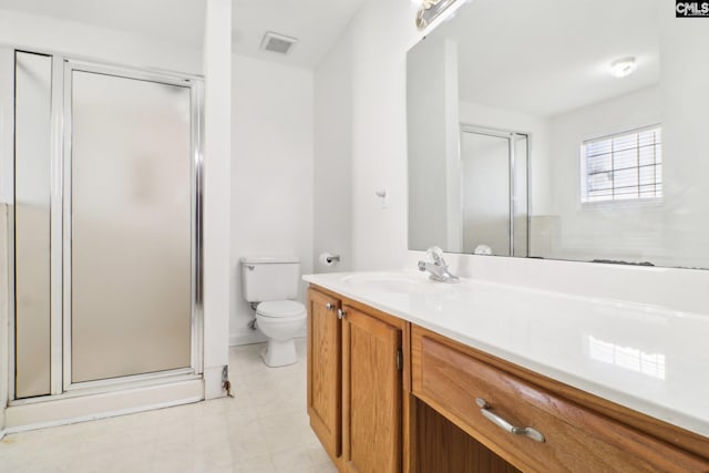 bathroom with vanity, toilet, and a shower with shower door