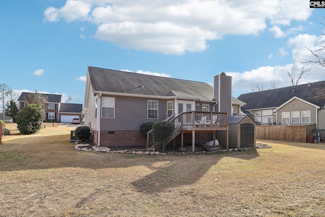 rear view of house featuring a yard, a deck, and a shed