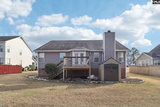 rear view of house with a wooden deck, a storage unit, and a yard