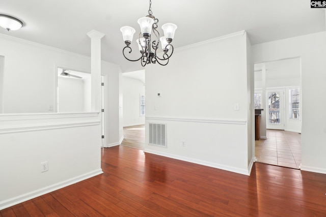 unfurnished dining area featuring crown molding, dark wood-type flooring, and ceiling fan with notable chandelier