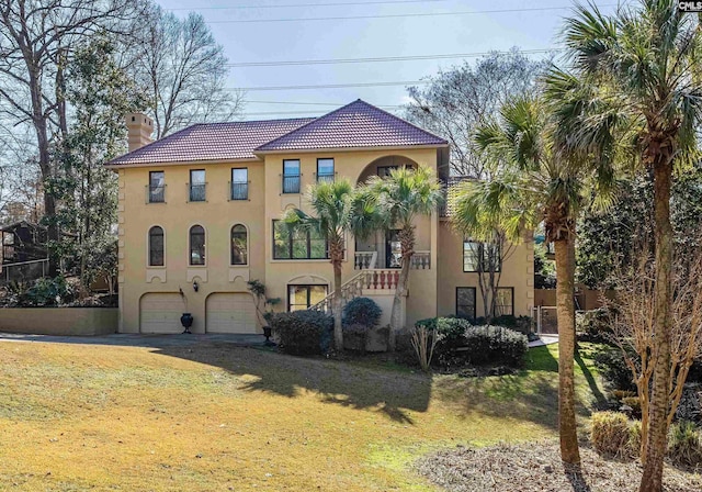 mediterranean / spanish-style home featuring a garage and a front yard