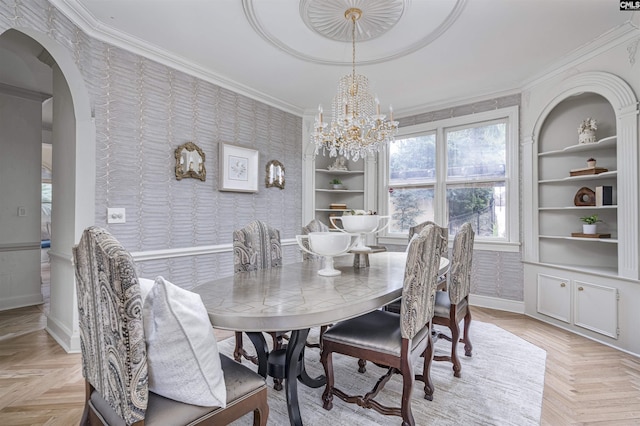 dining space with light parquet floors, ornamental molding, a chandelier, and built in shelves