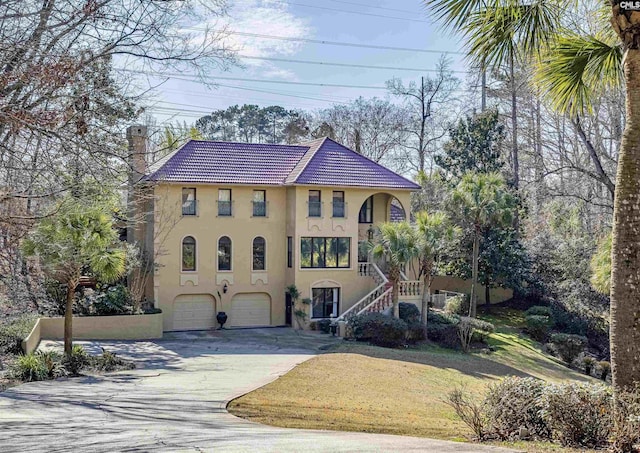 mediterranean / spanish-style home with a garage and a front yard