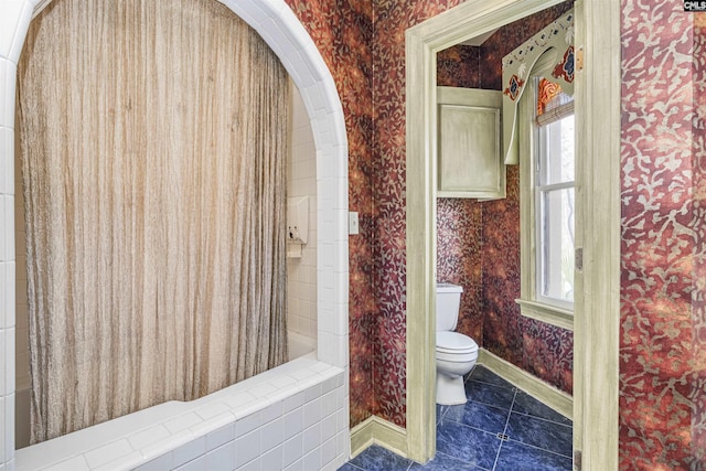 bathroom featuring tile patterned flooring, walk in shower, and toilet