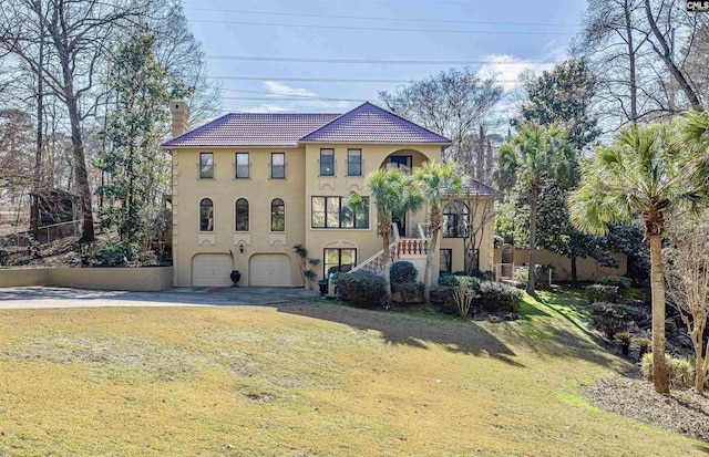 mediterranean / spanish home with a garage and a front yard