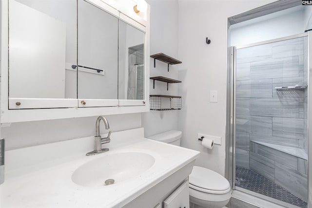 bathroom featuring vanity, toilet, and a shower with shower door