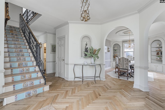 entryway featuring an inviting chandelier, ornamental molding, and light parquet floors