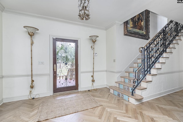 foyer entrance with crown molding and parquet flooring